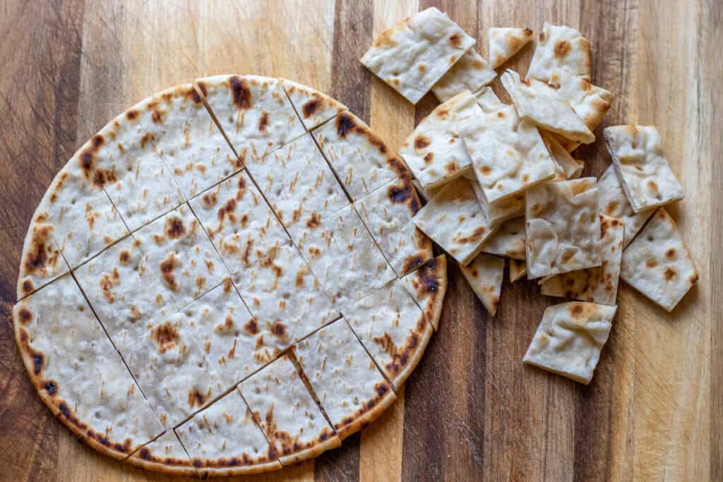 Pita bread is cut into bite-sized cubes.