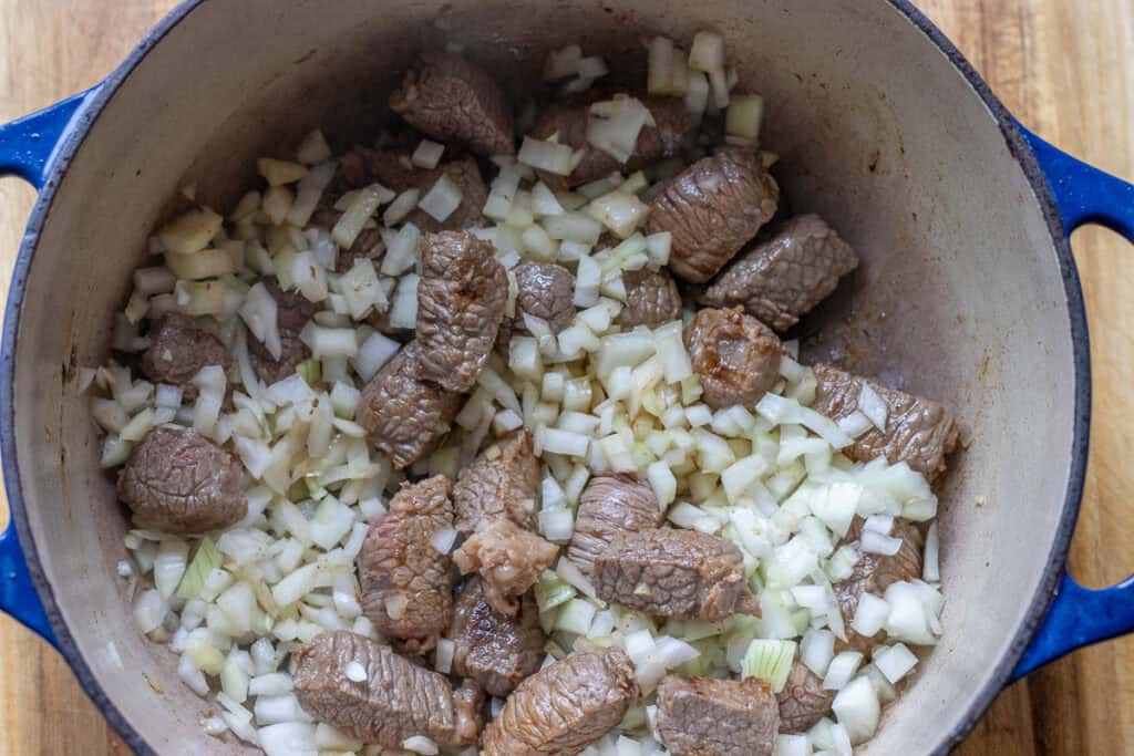 Sautéing chopped onions and garlic until soft.