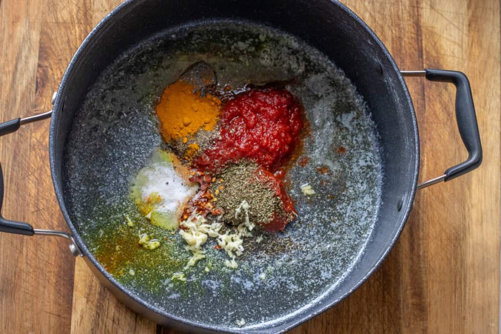 Melted butter, tomato paste, red pepper paste, and seasoning added to the pot.
