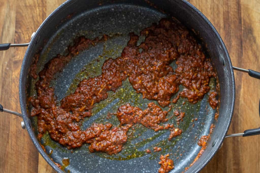 Sautéing the pastes with the spices.