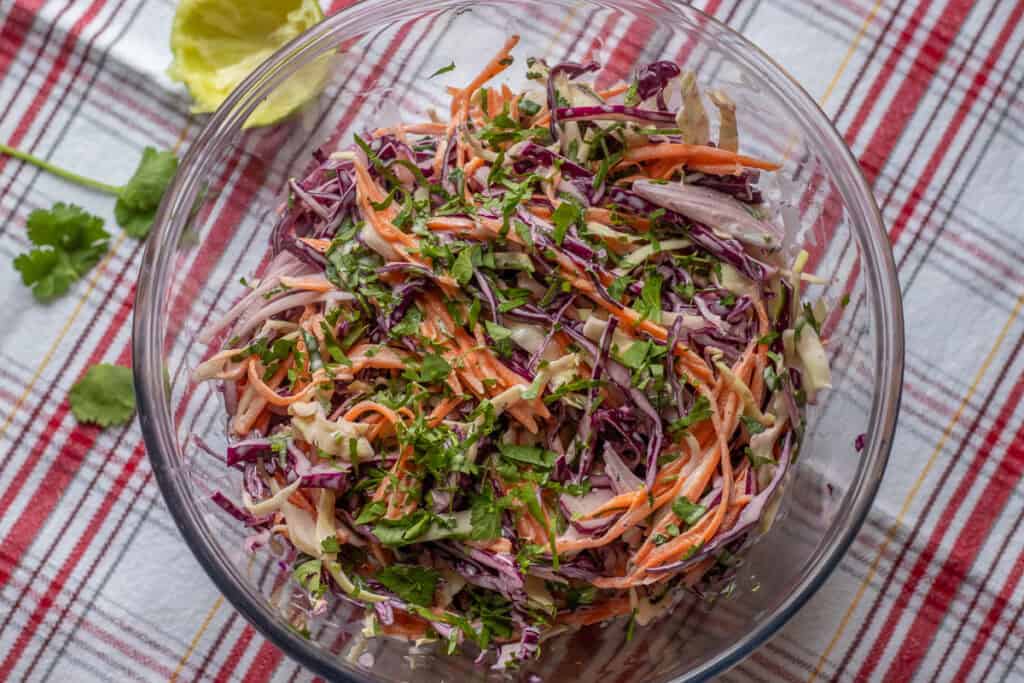The slaw is served in a glass bowl.