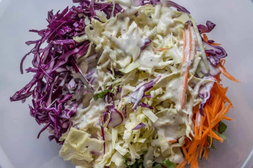 Dressing is poured over finely shredded vegetables.