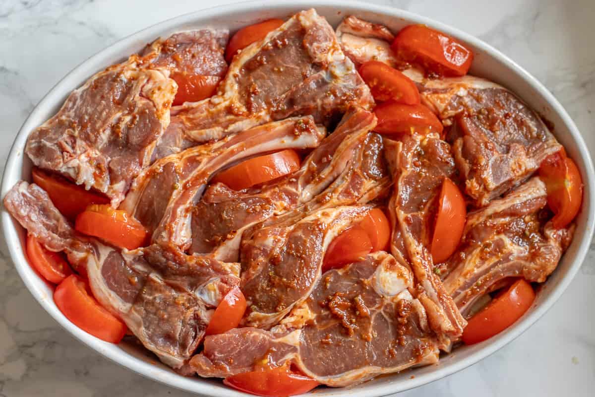 lamb chops are placed on top of vegetables