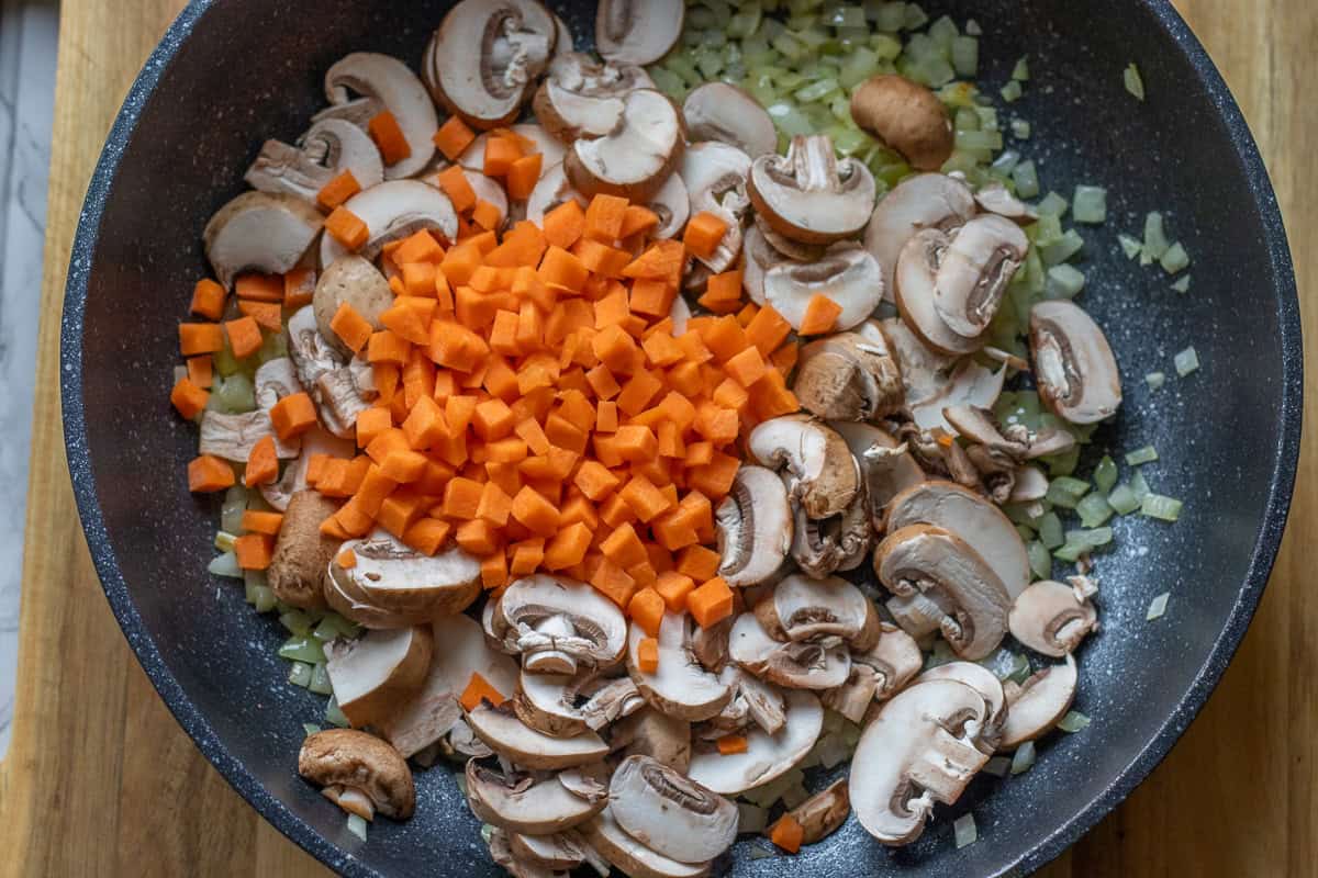 garlic, carrots, and mushroom are added to onions