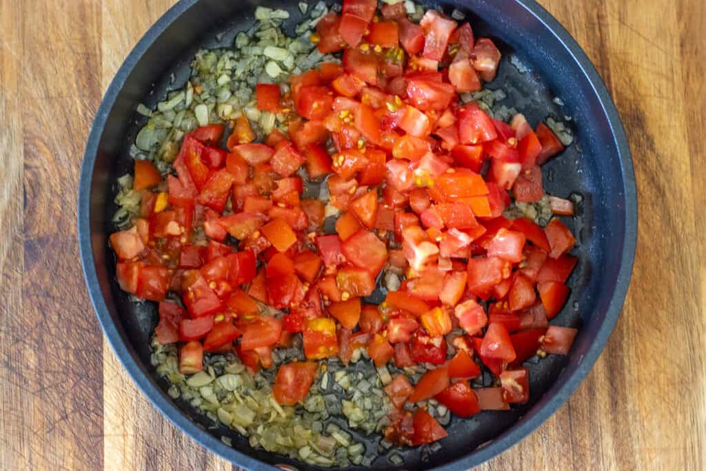 Chopped tomatoes are added to the pan.