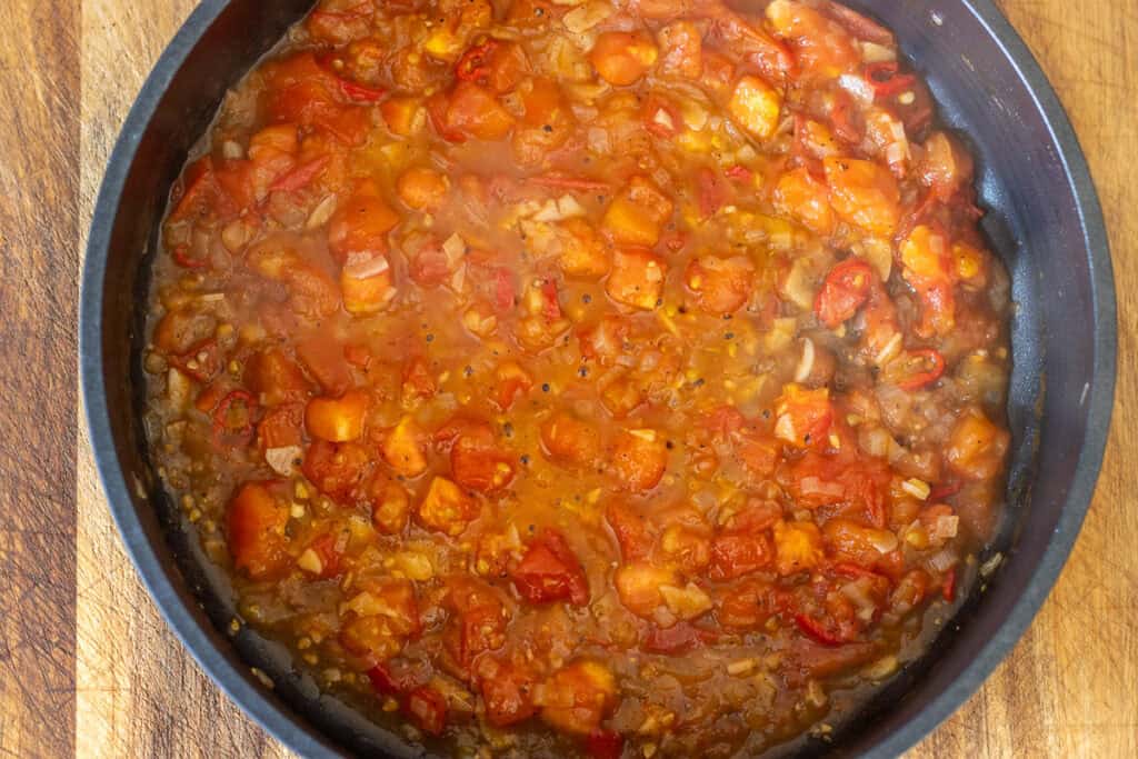 Tomato and chilli sauce simmering in a pan.