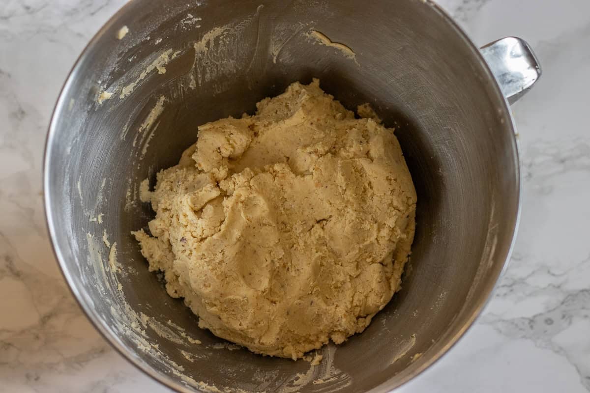 flour, corn starch, ground nuts are added to creamed butter mixture