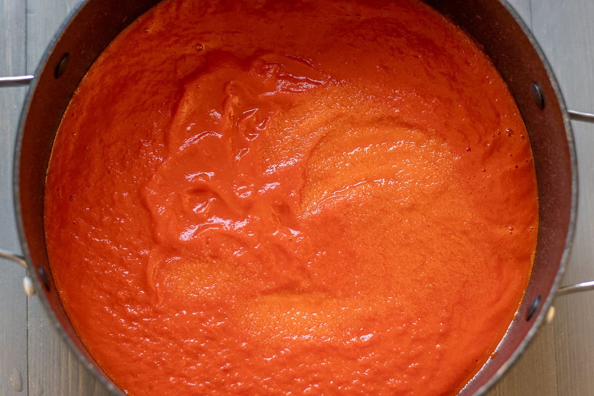 blitzed red peppers are placed in a pot