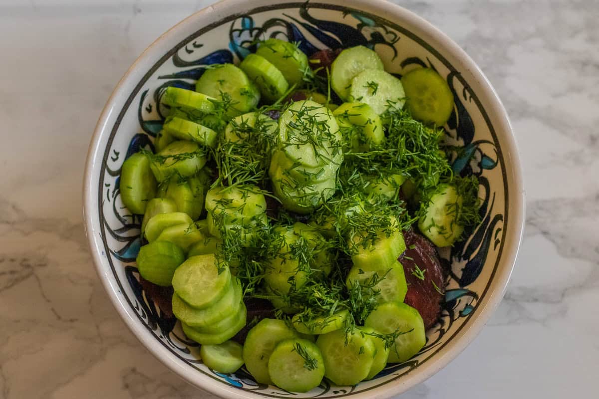 sliced cucumbers and beets are plaved in a bowl