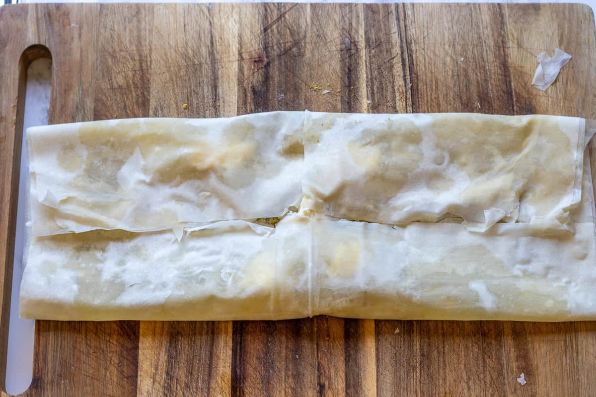 Folding the sides of filo pastry to shape katmer.