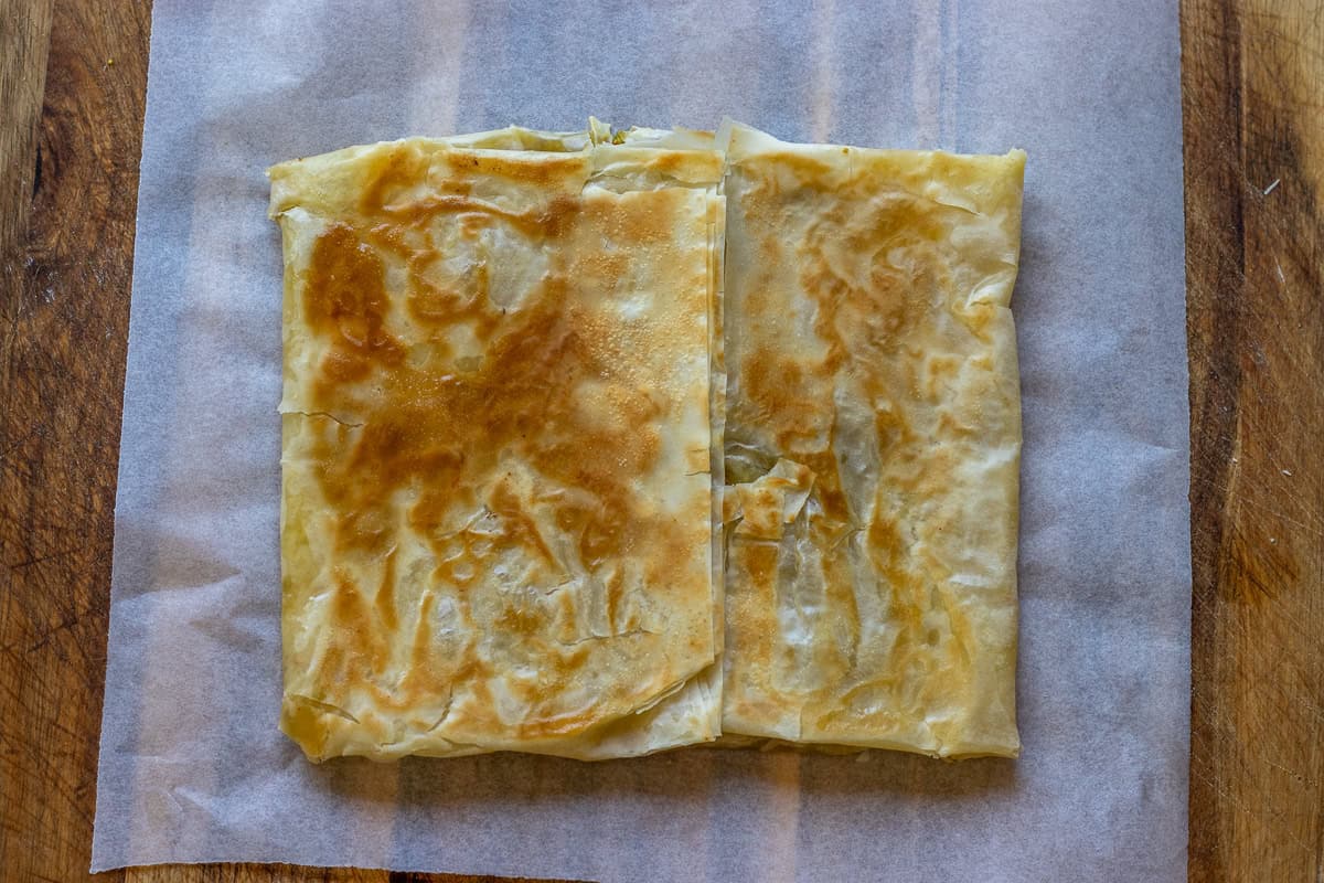 The pastry is cooked until golden and flaky in a skillet.