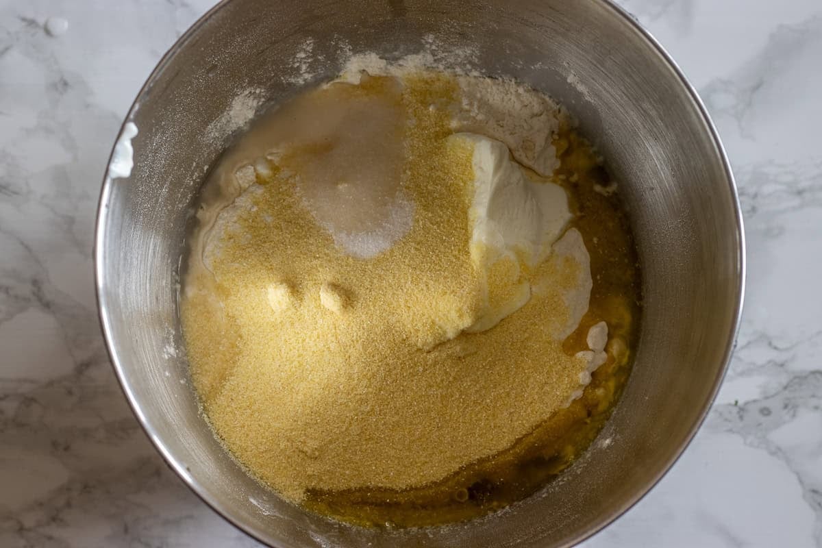 Flour, semolina, honey, olive oil, water, yeast, and salt are placed in a bowl of a stand mixer.