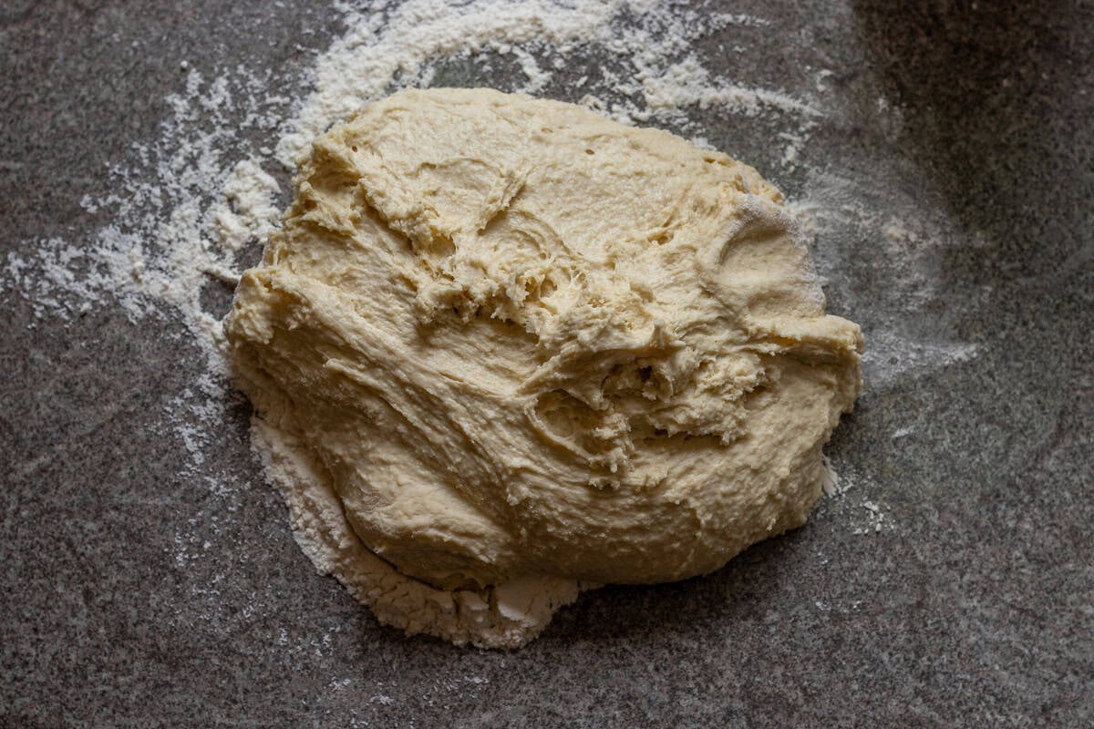 Soft and sticky bread dough on a lightly floured worktop.
