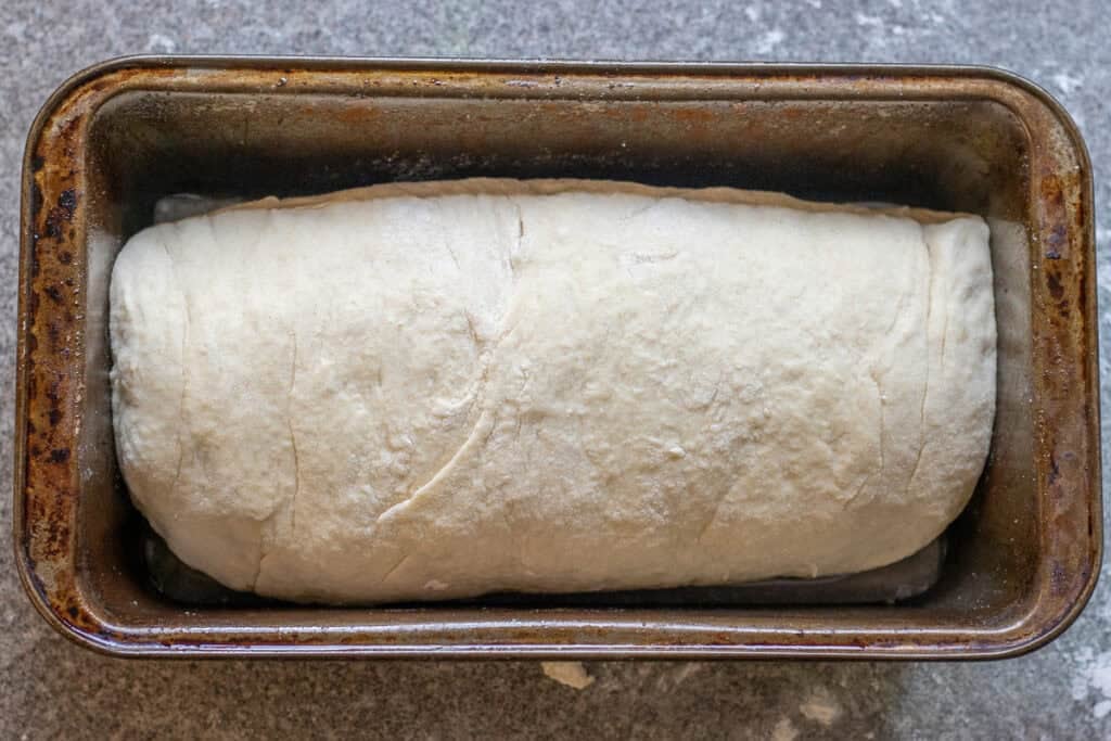 The log shaped dough is placed in a prepared tin.