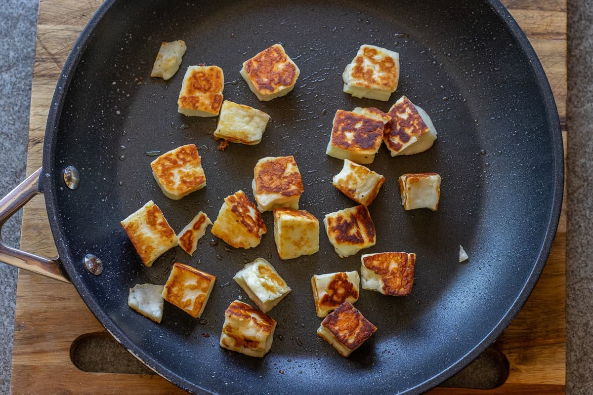 Halloumi cubes are fried in a pan until golden brown and nicely caramelised.