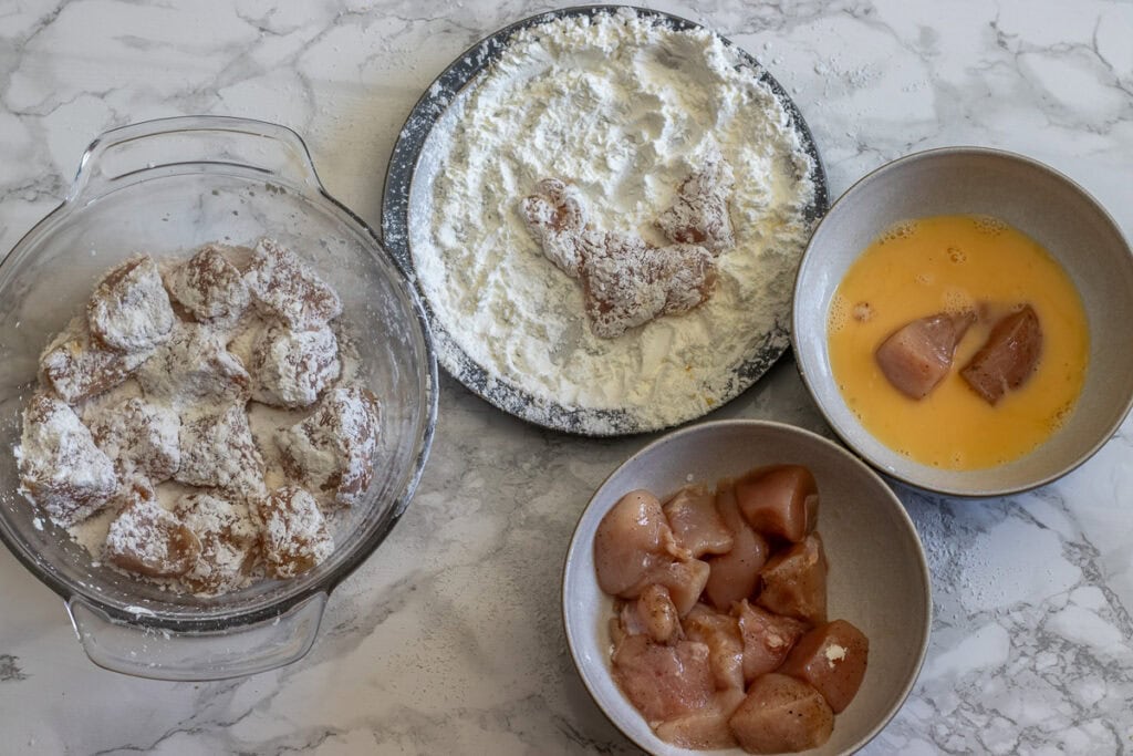Chicken cubes are dunked in eggs, then covered with cornstarch.