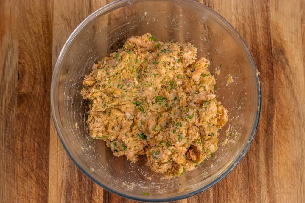 The mixed salmon patty mixture in a glass bowl.