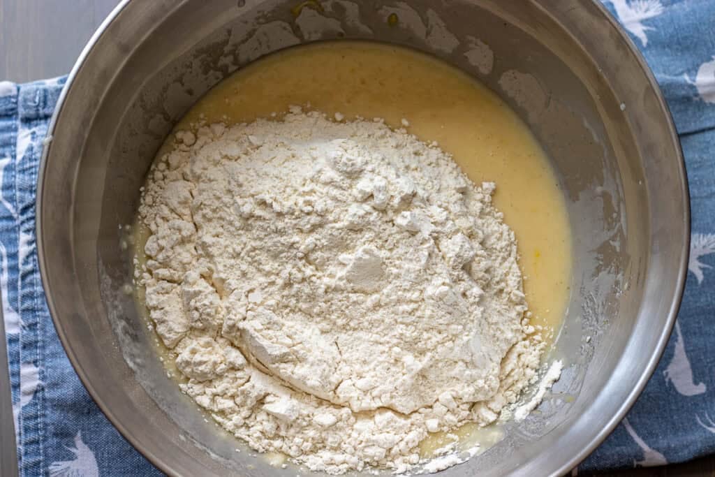 Dry ingredients added to the wet mixture in a bowl.
