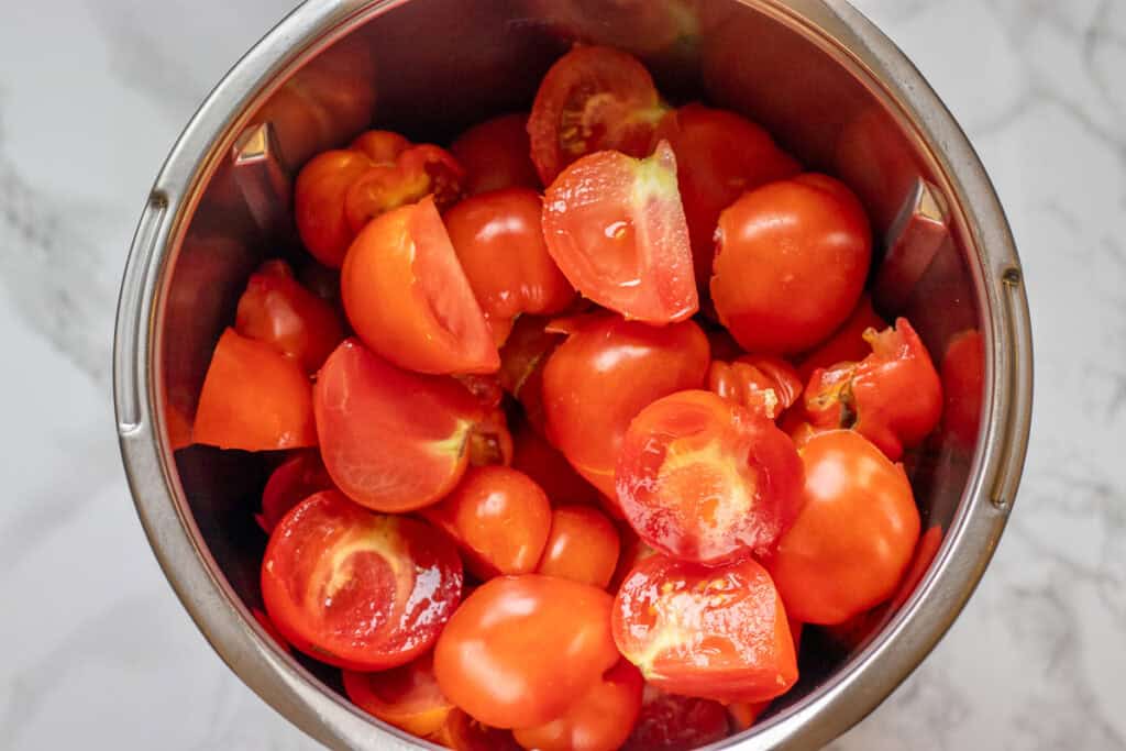 Quartered raw tomatoes in the blender bowl.