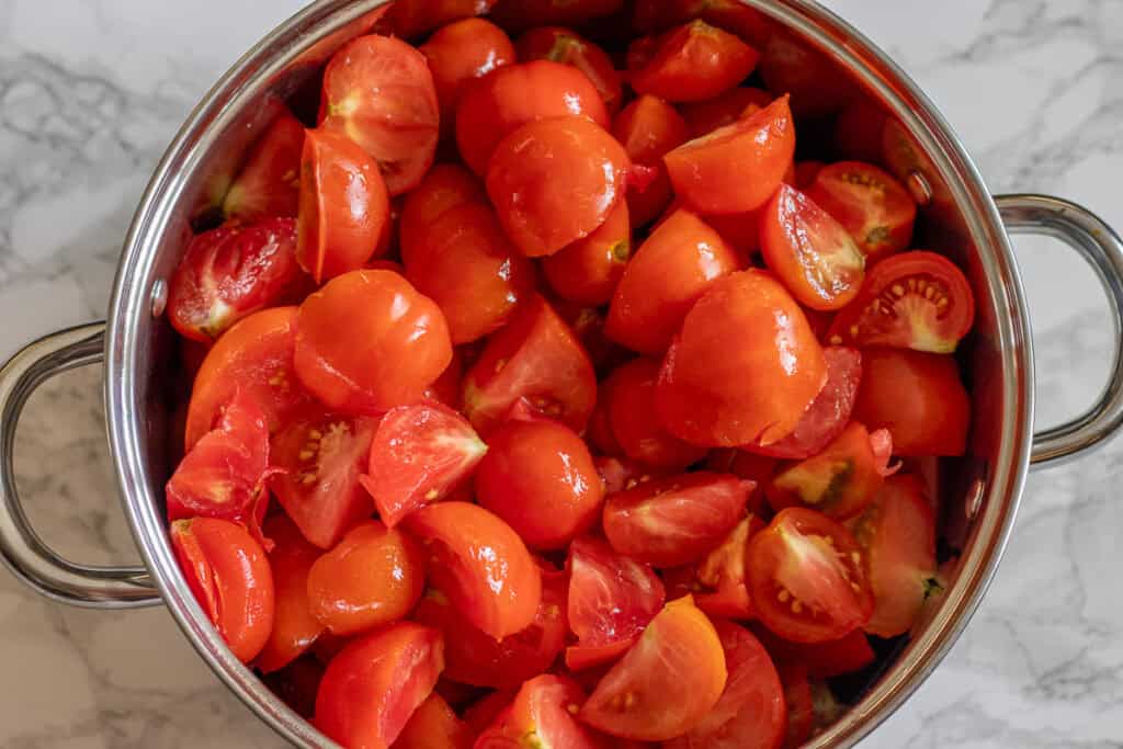 Quartered tomatoes in a large pot.