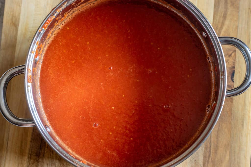 Sieved tomato juice in a wide pot before reducing.