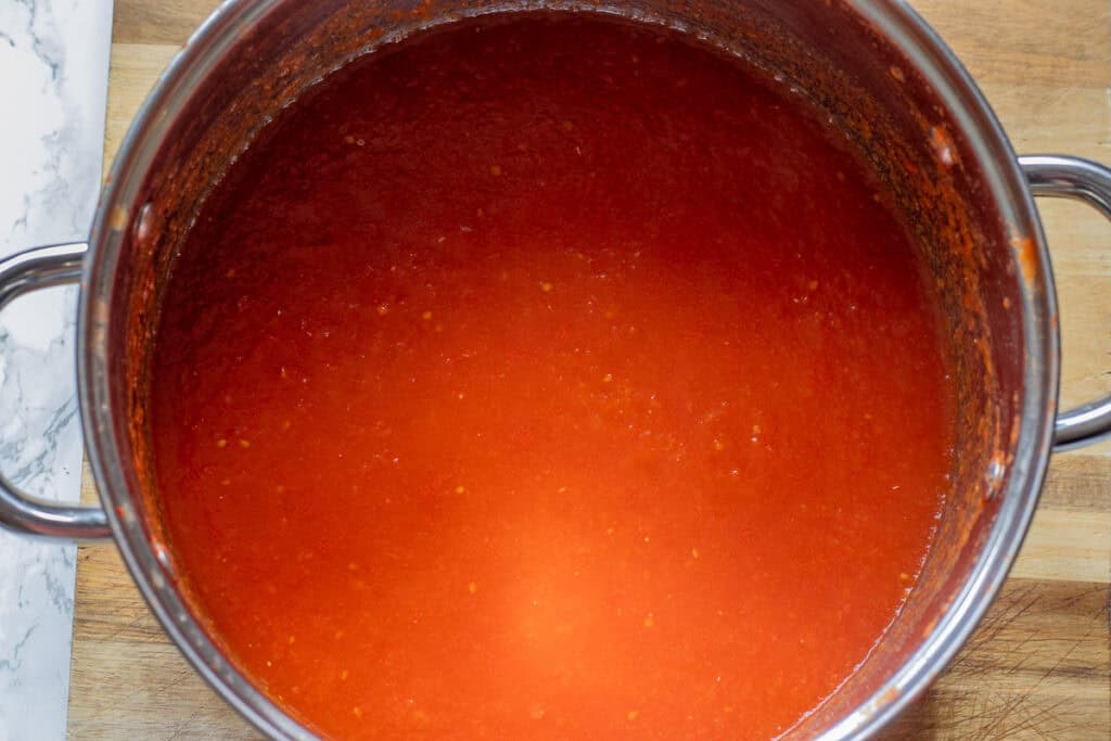 Tomato sauce thickening in the pot as it simmers.