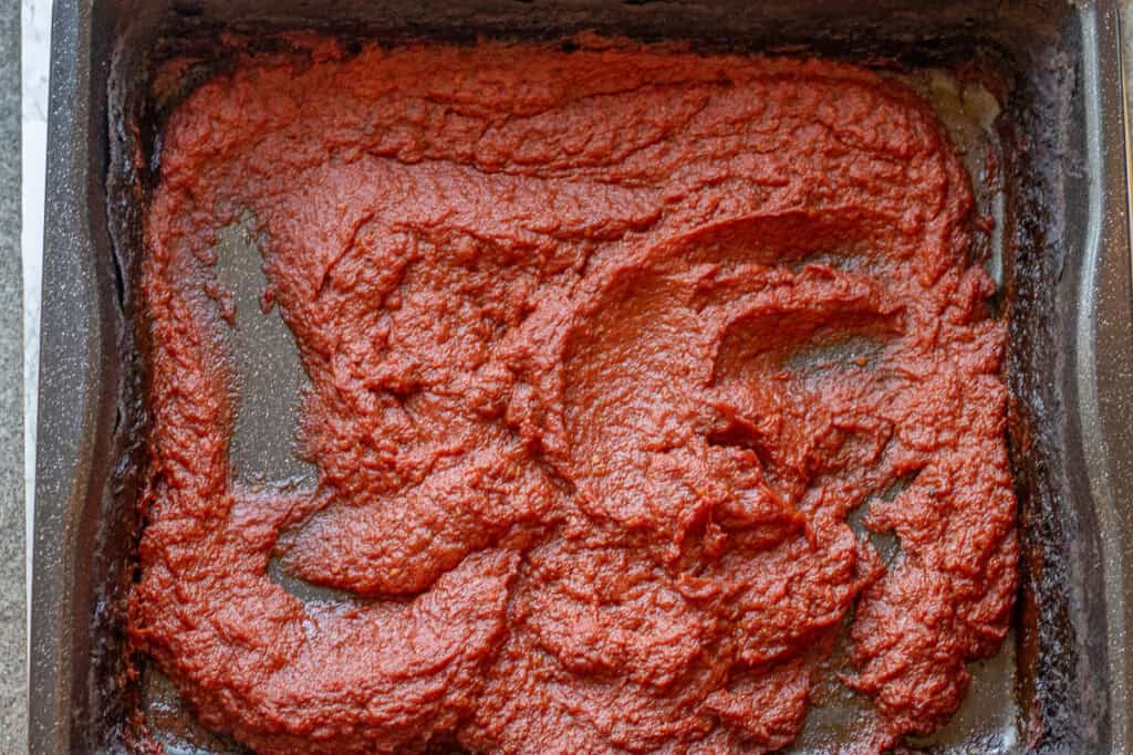 Thick dark red tomato paste on the tray after the oven.